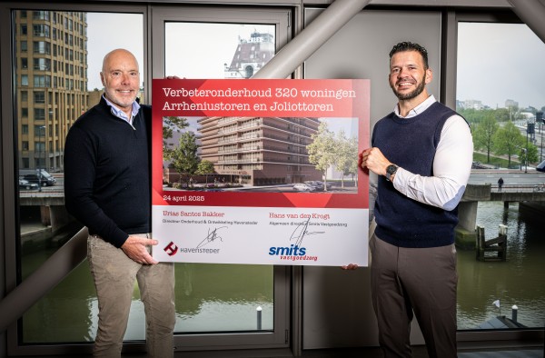Hans van der Krogt van Smits Vastgoedzorg & Urias Santos Bakker van Havensteder houden samen het bord met de ondertekening van de samenwerking vast