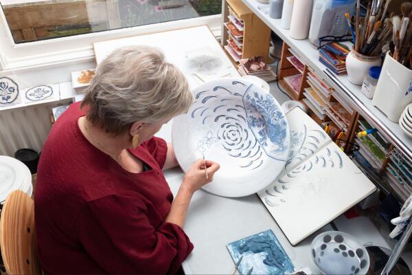 Plateelschilder Trudy Otterspeer aan het werk in haar atelier.